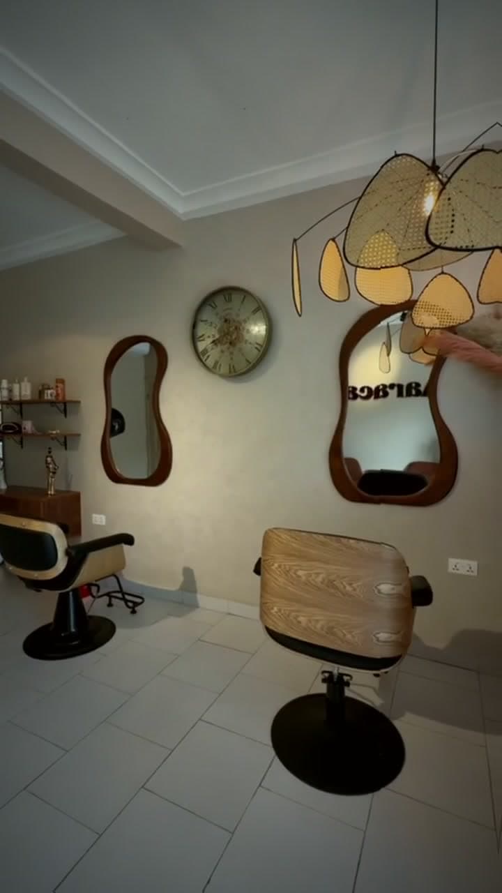 Sculpted wooden mirrors and a rattan pendant above the styling chair